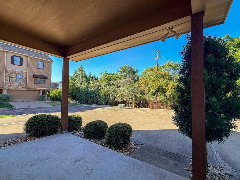 2410 S 2nd Street, #1373, Waco, TX 76706 Covered patio with concrete flooring, accented by landscaped river rock beds and established shrubbery