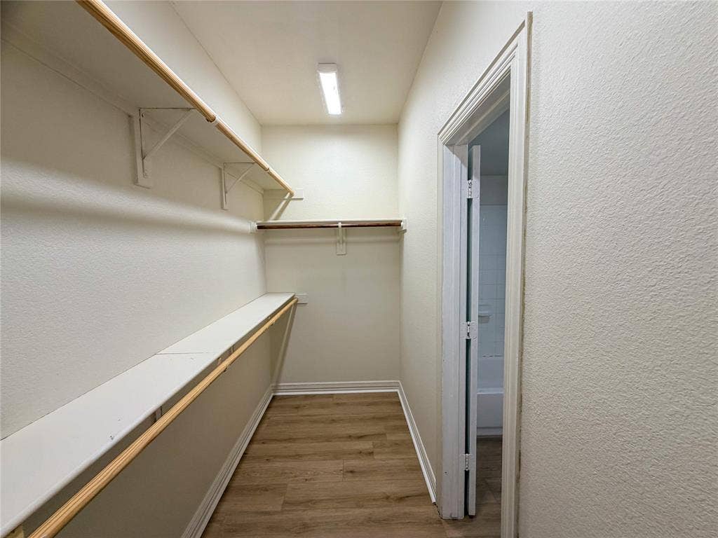 2410 S 2nd Street, #1373, Waco, TX 76706 Walk-in closet with wood-finish flooring, built-in shelving, and hanging rods