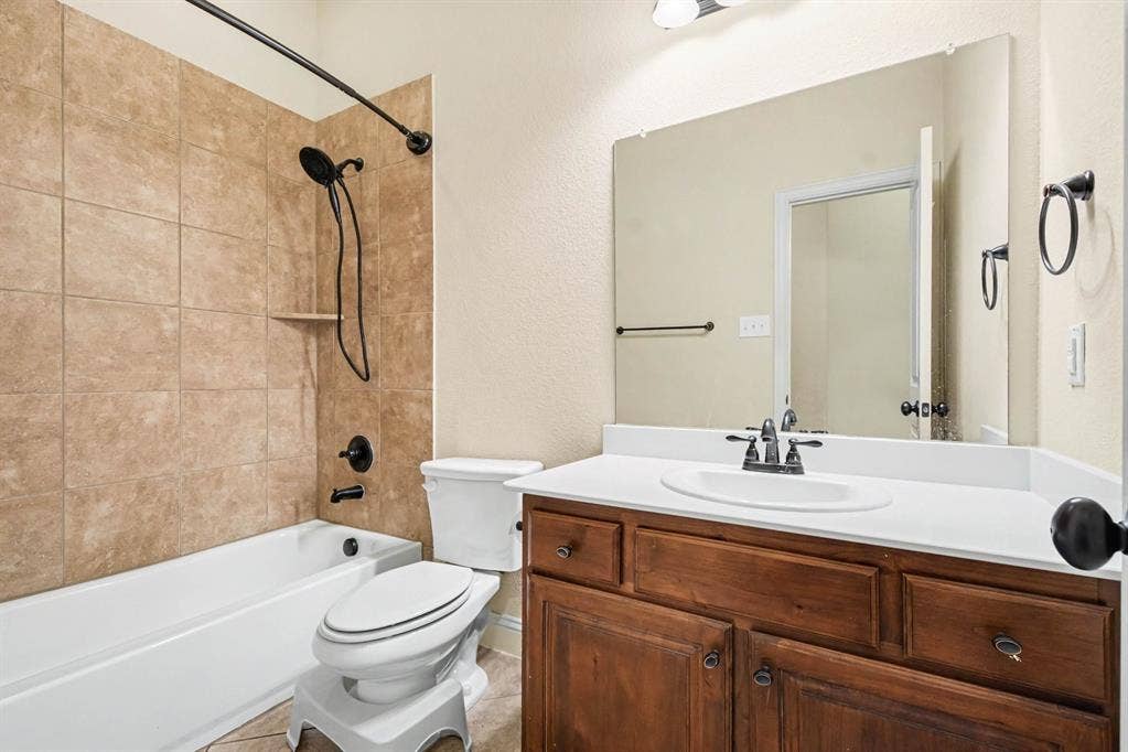 1005 Seminole Lane, Greenville, TX 75402 A full bath with a tiled tub and shower.