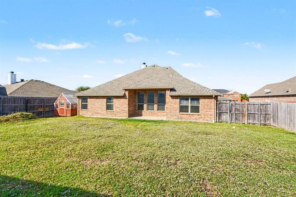 1005 Seminole Lane, Greenville, TX 75402 A covered patio overlooking the fenced lawn.