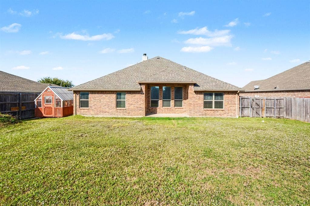 1005 Seminole Lane, Greenville, TX 75402 A broad backyard with a covered patio.