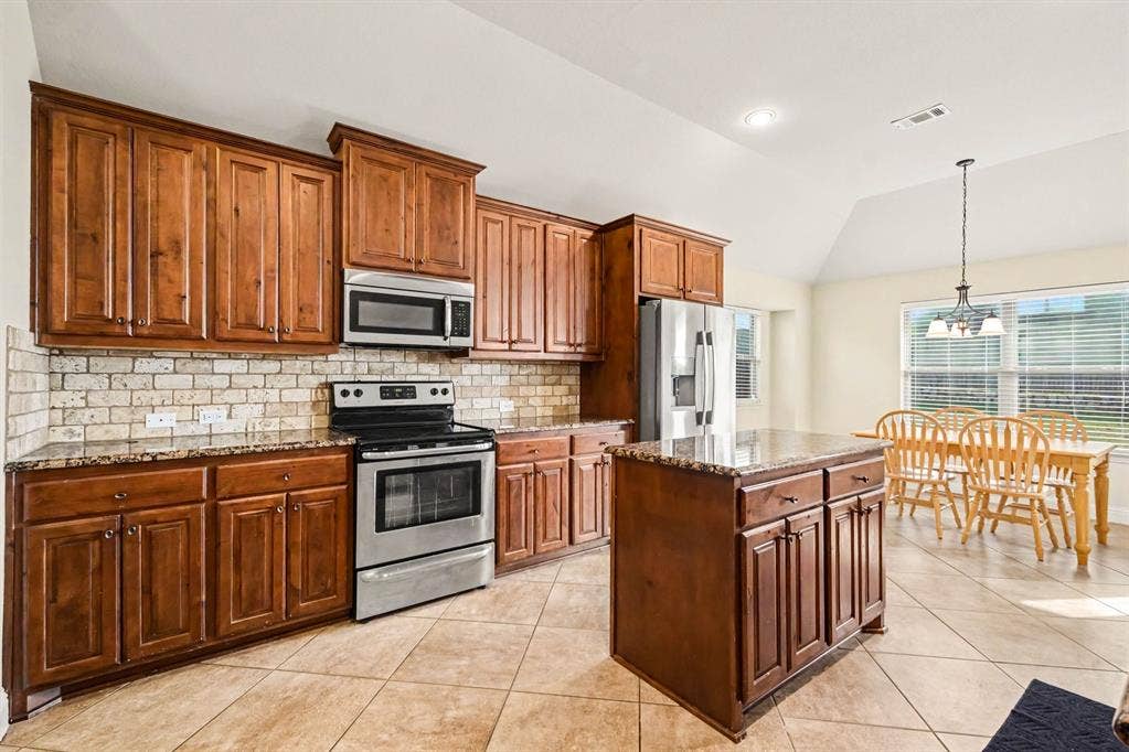 1005 Seminole Lane, Greenville, TX 75402 Warm wood cabinetry and a center island.