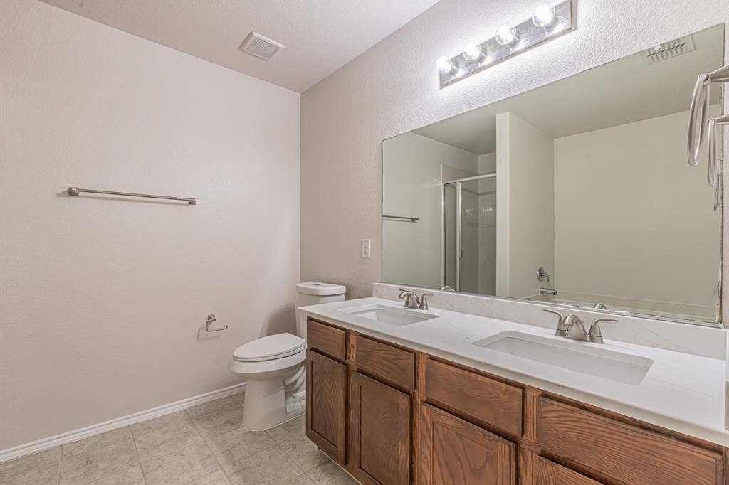 Double vanity featuring integrated sinks and brushed nickel faucets set into a light-toned countertop