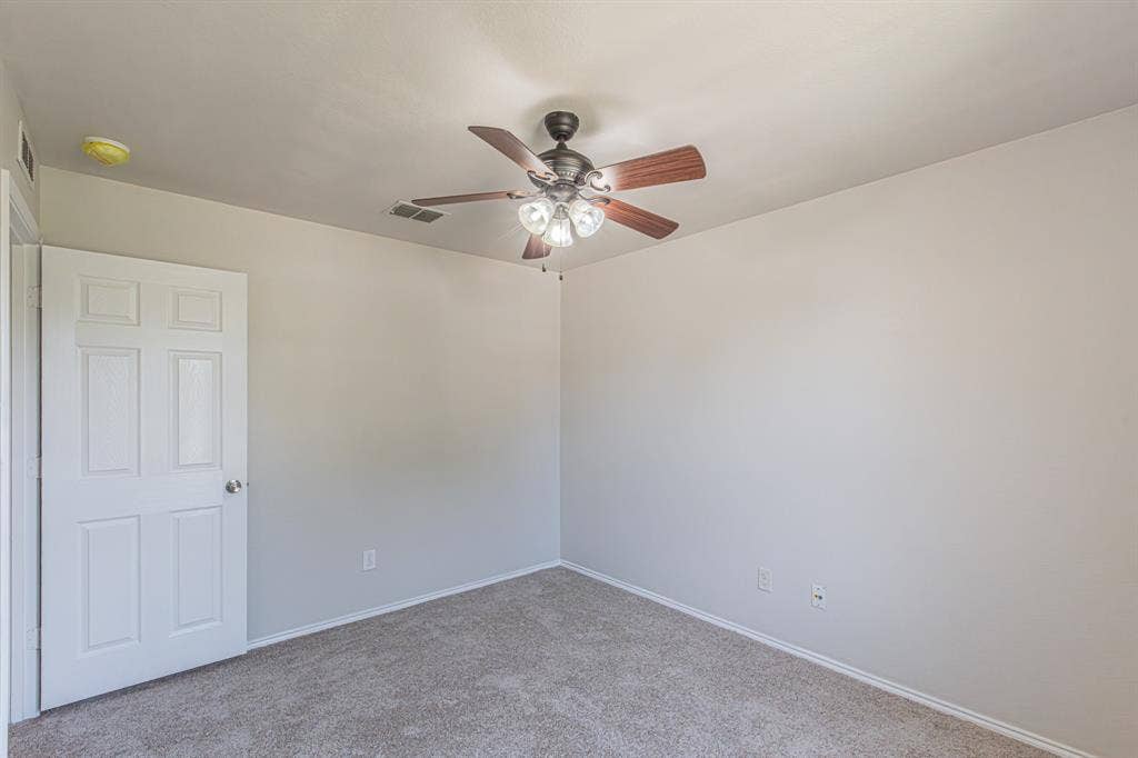 Room featuring neutral carpet, light-toned walls, and a ceiling fan with integrated lighting