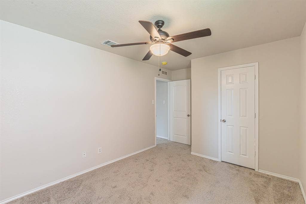 Spacious room featuring neutral carpet flooring and light-toned walls