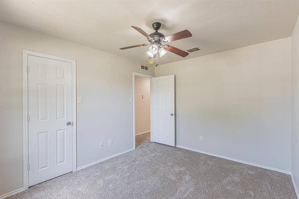 Neutral-toned walls complement the light-colored carpet flooring
