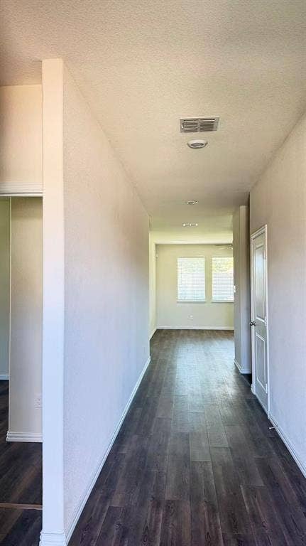 Neutral wall tones, wood-finish flooring, and recessed ceiling lighting, punctuated by paneled interior doors and dual window treatments