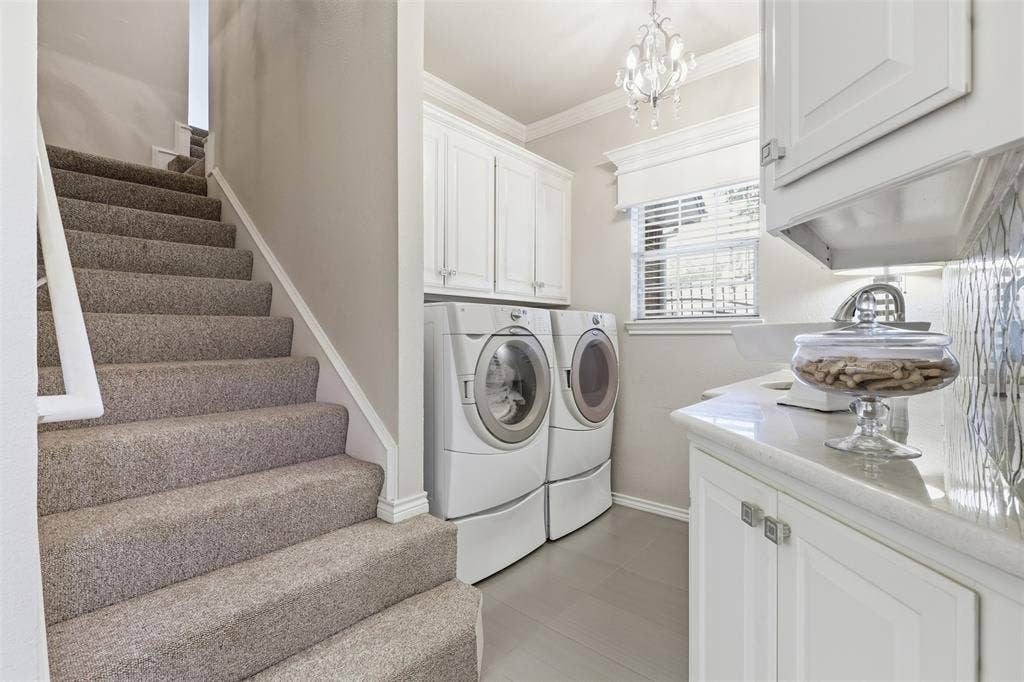 Laundry room with steps leading to bonus room