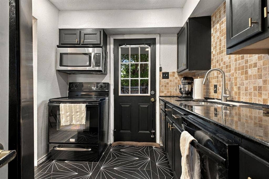 4904 Lahoma Street, #4904, Dallas, TX 75235 Kitchen featuring dark cabinetry, polished stone countertops, mosaic tile backsplash, geometric patterned flooring, and a stainless steel appliance suite