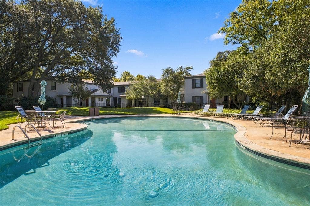4904 Lahoma Street, #4904, Dallas, TX 75235 Swimming pool with concrete decking, surrounded by mature trees and landscaped grass areas