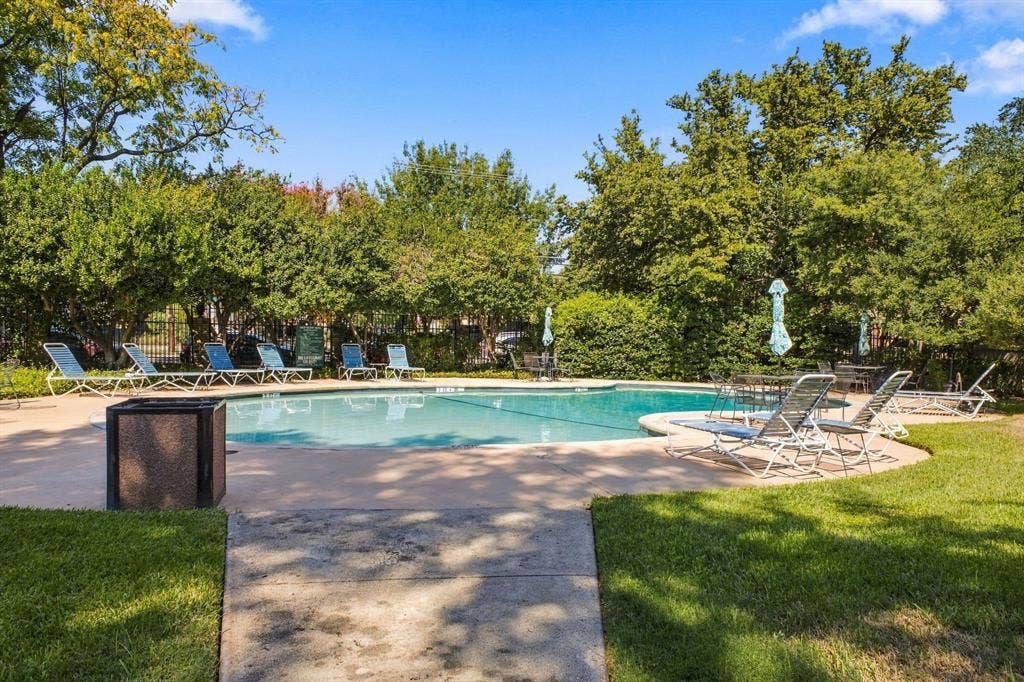 4904 Lahoma Street, #4904, Dallas, TX 75235 In-ground swimming pool featuring a concrete surround, surrounded by mature trees and landscaped grounds