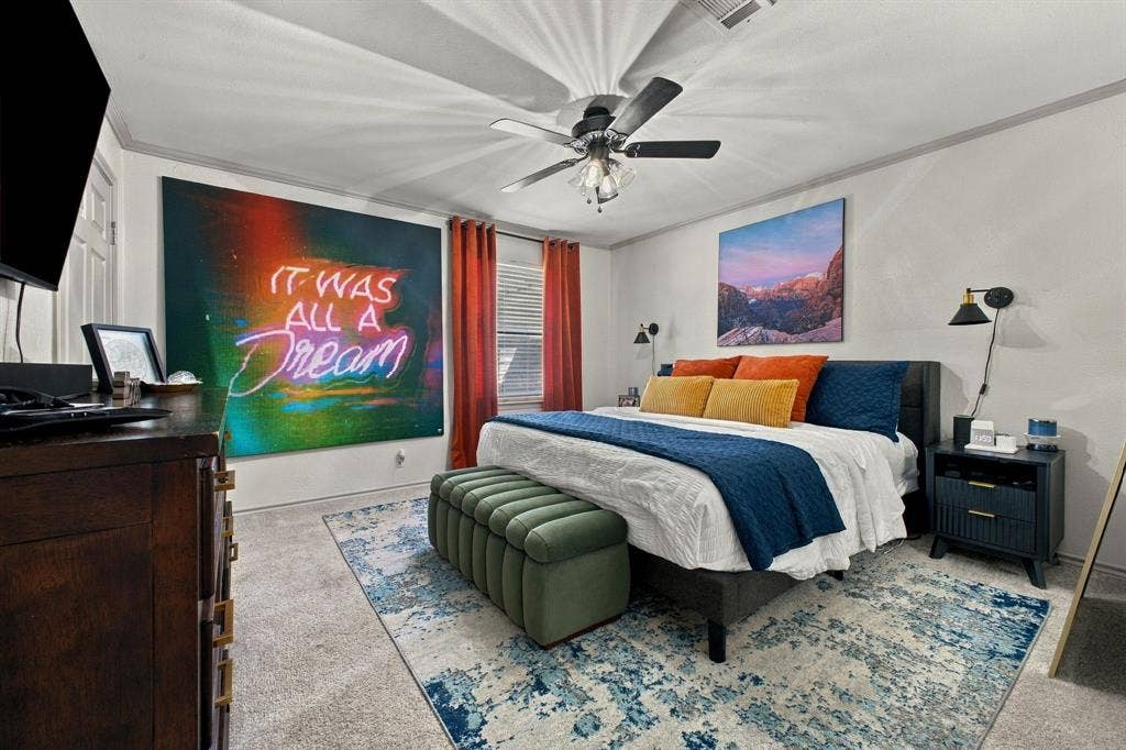 4904 Lahoma Street, #4904, Dallas, TX 75235 Bedroom featuring neutral wall-to-wall carpeting, crown molding, a central ceiling fan with integrated lighting, and two wall-mounted adjustable sconces