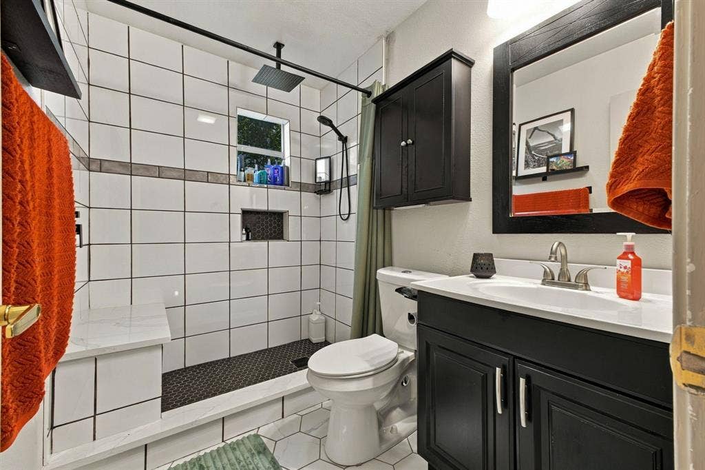 4904 Lahoma Street, #4904, Dallas, TX 75235 Bathroom featuring a vanity with a white countertop, dark cabinetry, and a matching framed mirror
