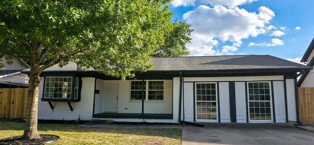 513 Vernet Street, Richardson, TX 75080 Single-story residence featuring white painted brick exterior, dark trim accents, a front-facing bay window, and a covered entryway