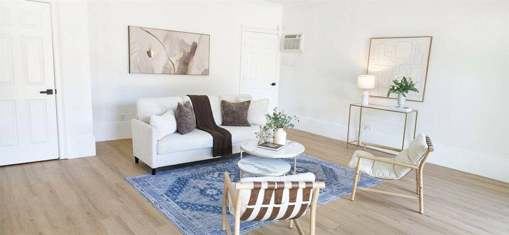 513 Vernet Street, Richardson, TX 75080 Living area featuring wood-finish flooring, white walls, and a wall-mounted cooling unit