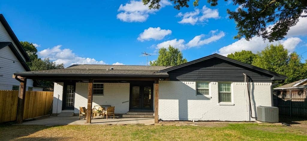 513 Vernet Street, Richardson, TX 75080 Exterior featuring a painted brick facade, covered patio with wood support beams, dark-finish exterior horizontal siding, and double-door entry