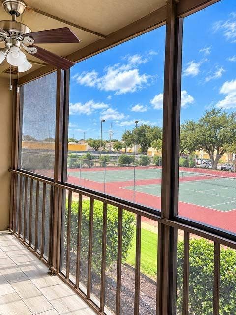 11450 Audelia Road, #104, Dallas, TX 75243 Screened-in porch featuring tiled flooring, a ceiling-mounted light fixture with fan, and metal railings