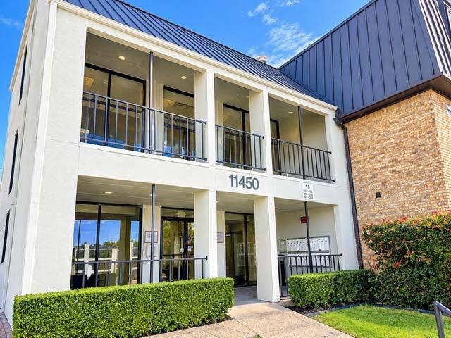 11450 Audelia Road, #104, Dallas, TX 75243 Multi-level exterior featuring a metal roof, stucco facade, second-story balcony with iron railings, and ground-level covered entryway