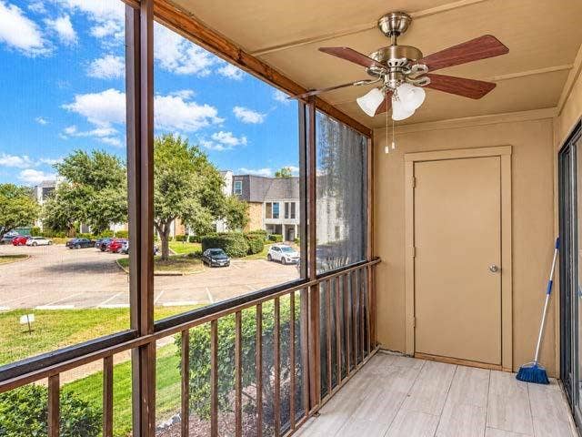 11450 Audelia Road, #104, Dallas, TX 75243 Screened-in balcony featuring wood-finish flooring, metal railing, integrated storage closet, and ceiling fan with light fixture