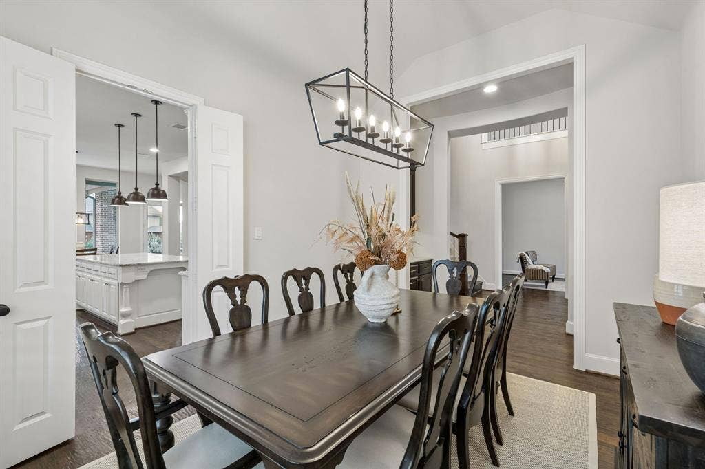 Dining room featuring wood-finish flooring, vaulted ceilings, and a geometric metal chandelier