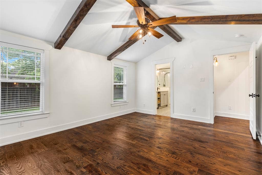 901 Oak Street, McKinney, TX 75069 Vaulted ceiling featuring exposed timber beams, wood-finish flooring, dual windows, and a ceiling-mounted light fixture