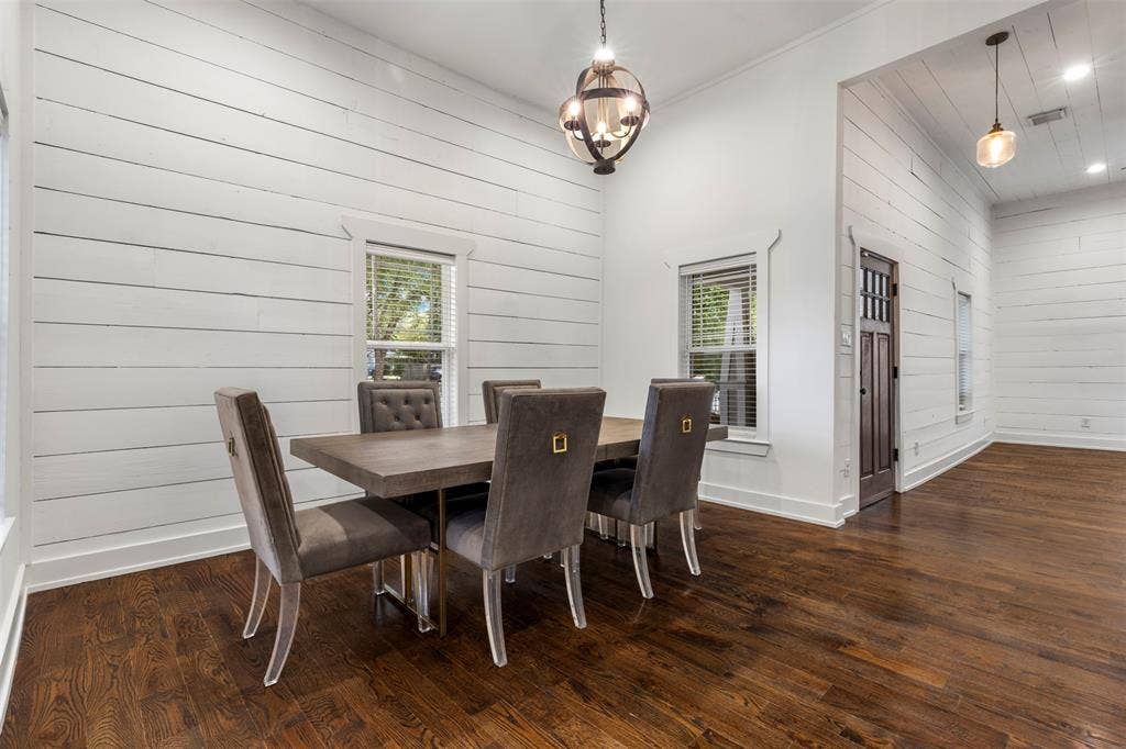 901 Oak Street, McKinney, TX 75069 High ceilings with white shiplap walls, wood-finish flooring, plank-style ceiling detailing, iron orb pendant lighting, and a dark-finish wood door with glass panes