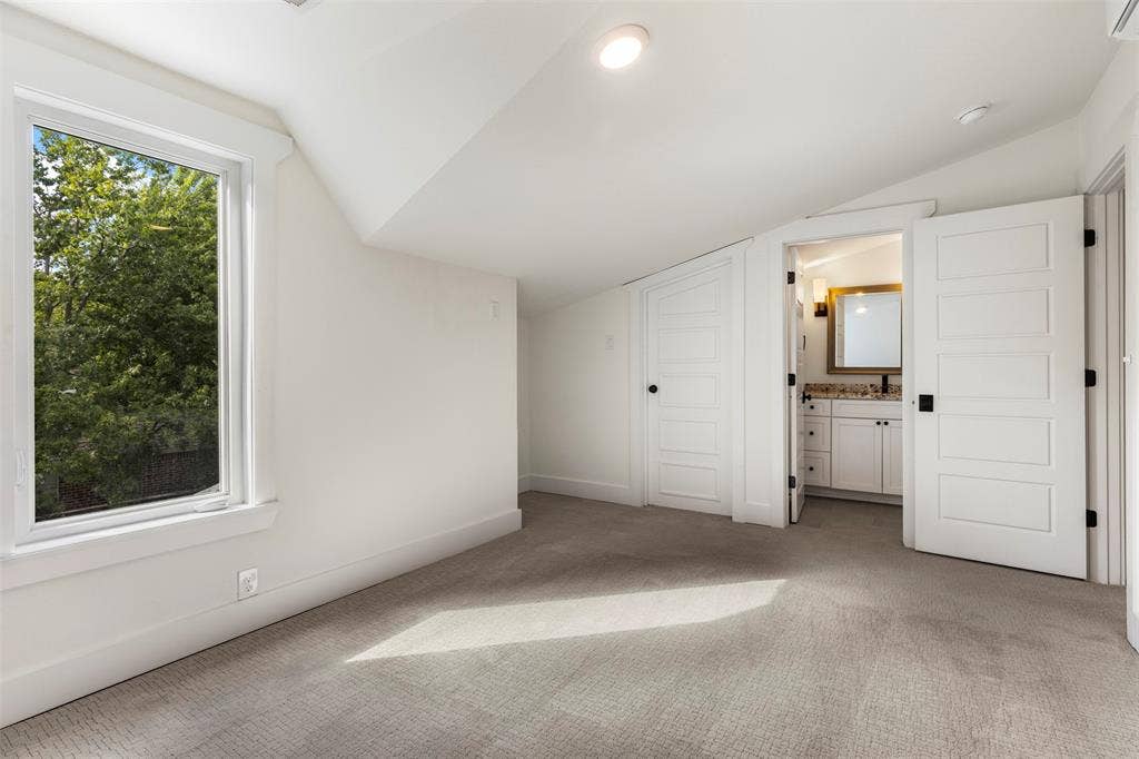 901 Oak Street, McKinney, TX 75069 Vaulted ceilings, neutral carpeting, large window with natural light, and five-panel solid-core doors