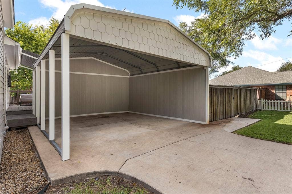 901 Oak Street, McKinney, TX 75069 Covered metal carport featuring a scalloped gable detail, vertical siding, and a concrete slab foundation