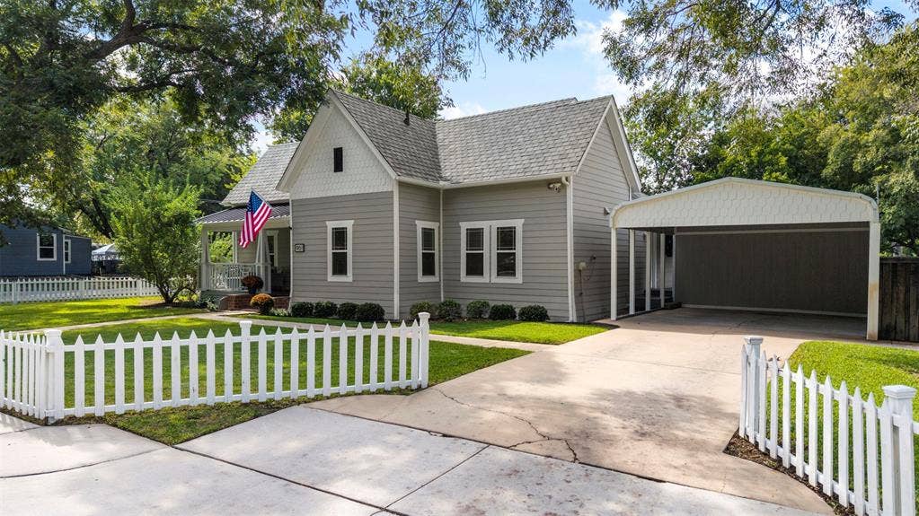 901 Oak Street, McKinney, TX 75069 Exterior featuring horizontal siding, a gabled roofline, a white picket fence, and a covered carport