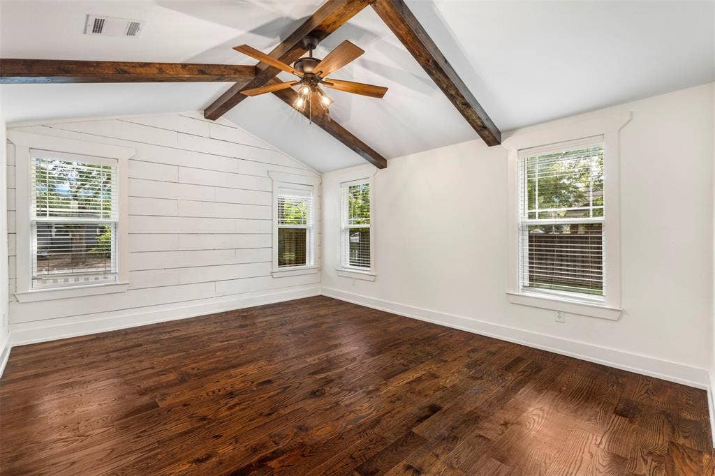 901 Oak Street, McKinney, TX 75069 Vaulted ceiling with exposed wood beams, wood-finish flooring, white horizontal plank wall detailing, and a multi-light ceiling fan