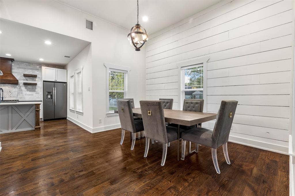 901 Oak Street, McKinney, TX 75069 Open floor plan featuring shiplap accent wall, dark wood-finish flooring, recessed lighting, and a spherical metal pendant fixture