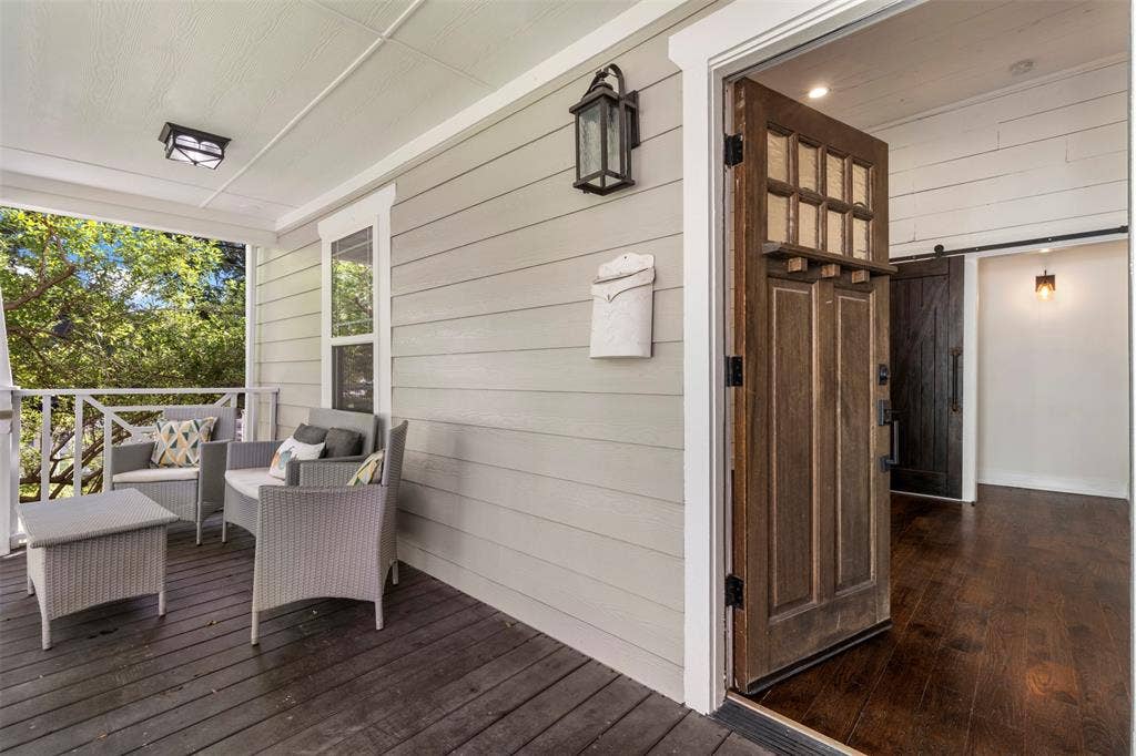 901 Oak Street, McKinney, TX 75069 Covered porch featuring horizontal lap siding, wood-finish decking, a multi-pane wood entry door, and dark wood-finish interior flooring