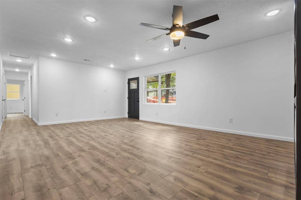 4813 Alandale Drive, Forest Hill, TX 76119 Open-concept room featuring wood-finish flooring, recessed lighting, a modern ceiling fan with integrated lighting, and a dark-finish exterior door with a decorative glass panel