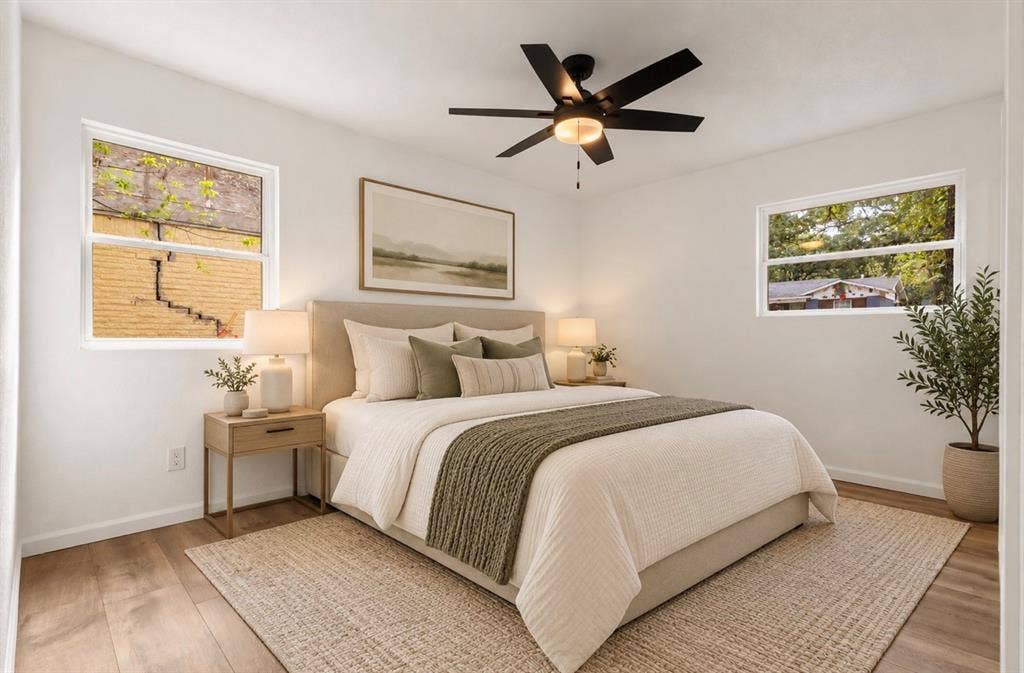 4813 Alandale Drive, Forest Hill, TX 76119 Bedroom featuring wood-finish flooring, dual windows providing natural light, and a black ceiling fan with integrated lighting virtually staged