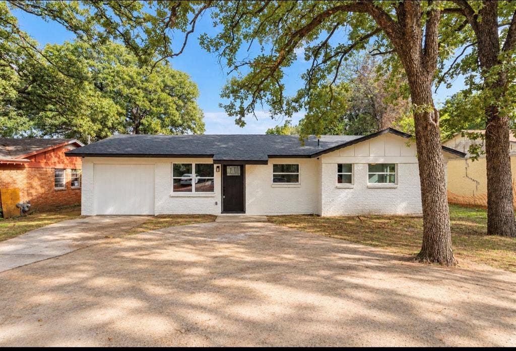 4813 Alandale Drive, Forest Hill, TX 76119 Single-story residence featuring a painted brick exterior, a composition shingle roof, an attached garage, and mature hardwood trees