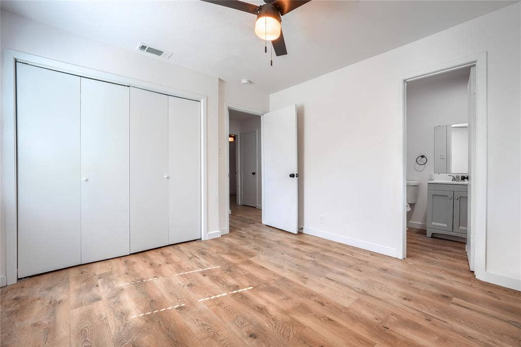 Room featuring wood-finish flooring, a ceiling fan with integrated lighting, and a large bi-fold closet