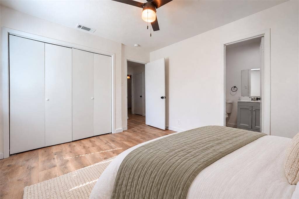 Room featuring wood-finish flooring, a multi-panel sliding closet, and a ceiling-mounted fan with integrated lighting