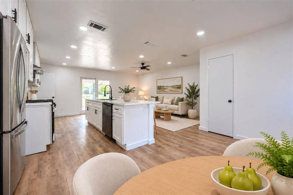 Kitchen featuring a center island with a stone-finish countertop, stainless steel appliances, recessed ceiling lighting, and wood-finish flooring