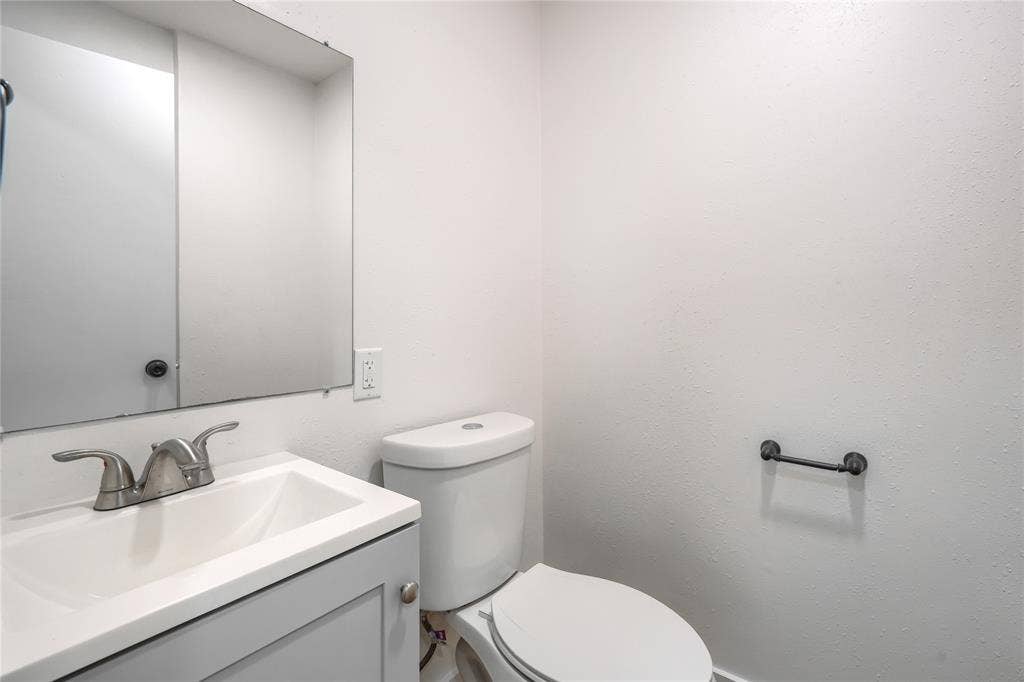 Single-sink vanity with a rectangular basin, polished metal faucet, integrated wall-mounted mirror, and matte black hardware