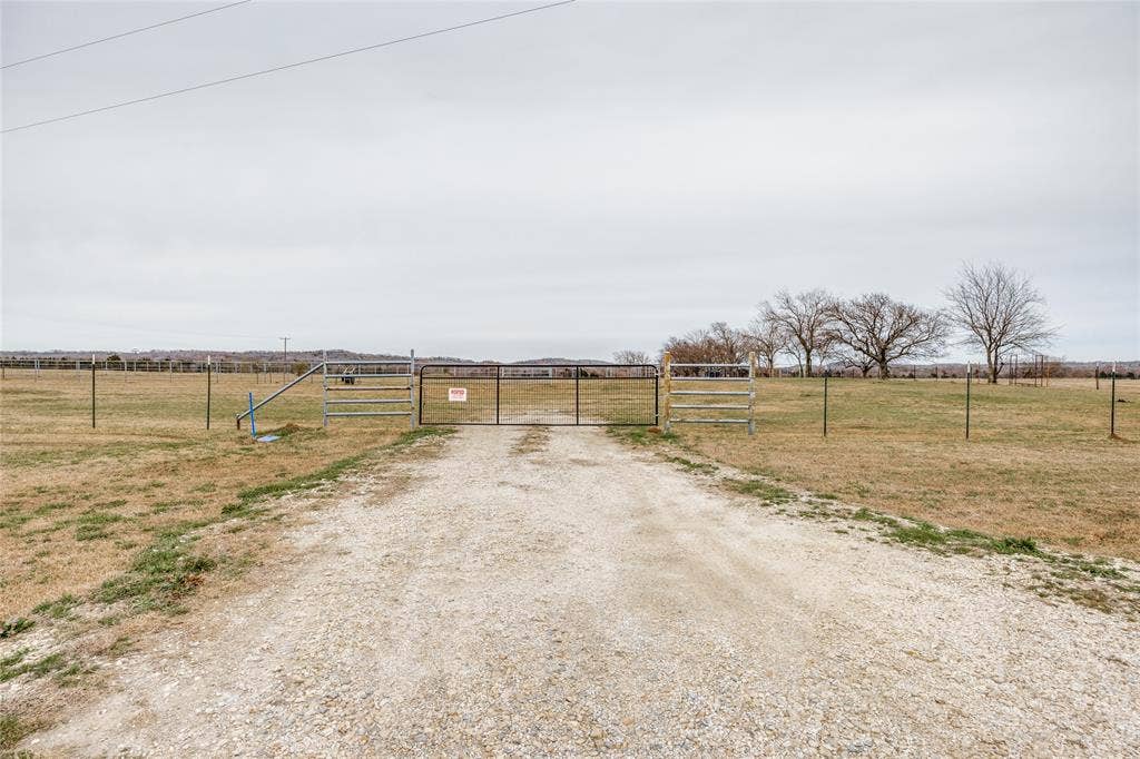 View of street with a gate, a view of countryside, and a gated entry