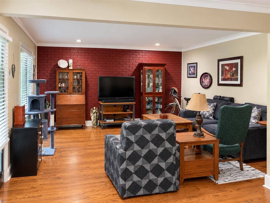 7730 Meadow Park Drive, #222, Dallas, TX 75230 Interior space featuring wood-finish flooring, a red-painted brick accent wall, recessed lighting, and crown molding