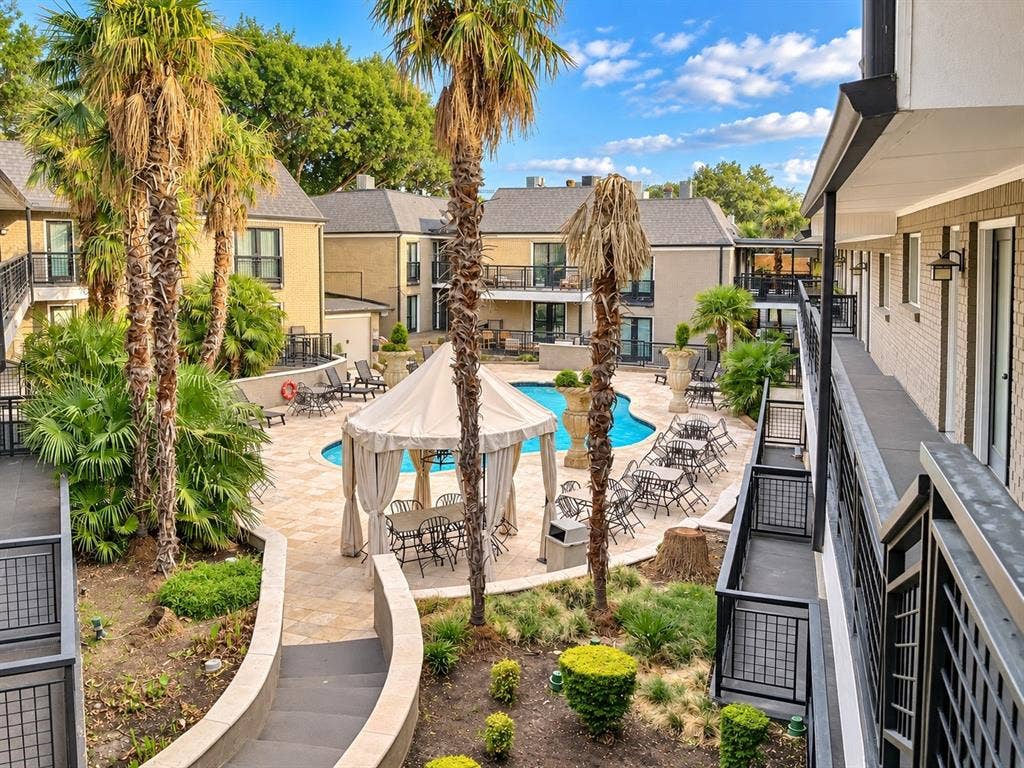 7730 Meadow Park Drive, #222, Dallas, TX 75230 Courtyard featuring an in-ground swimming pool, stone-paver hardscaping, established palm trees, and a central gazebo