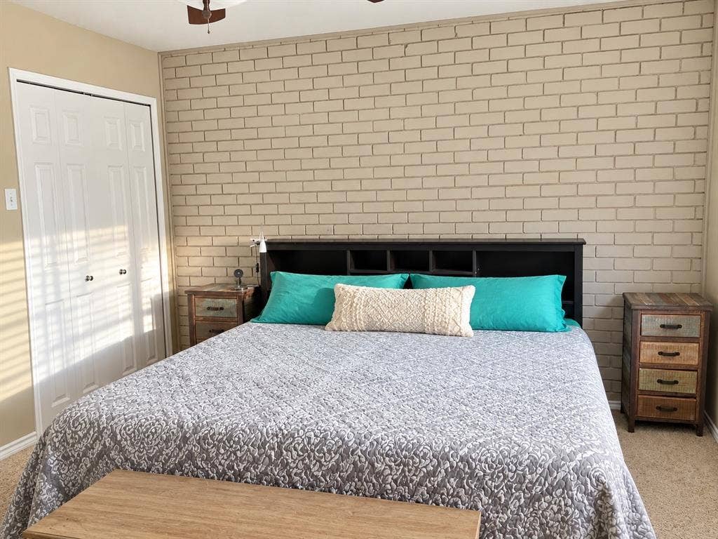 7730 Meadow Park Drive, #222, Dallas, TX 75230 Accent wall featuring painted brick masonry and double-door closet with paneled detailing