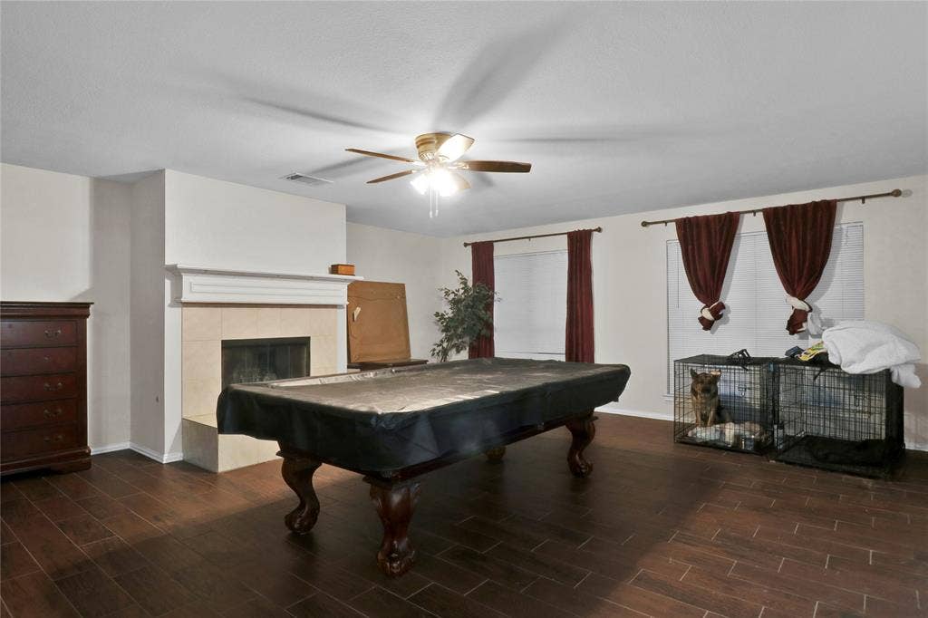 5753 Lionfish Way, Fort Worth, TX 76131 Downstairs den with fireplace and ceiling fan. Owner has their pool table set up there as perfect entertaining area off kitchen and leading to back yard.