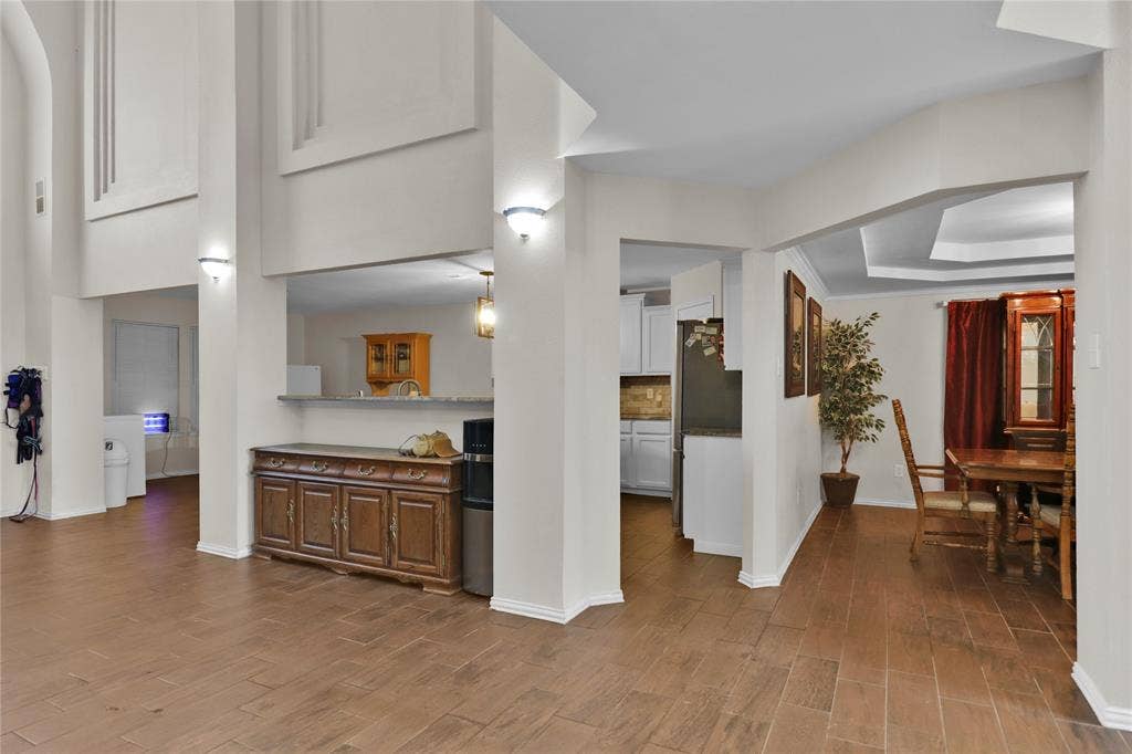 5753 Lionfish Way, Fort Worth, TX 76131 Formal dining to right. Kitchen in center and breakfast area to left. Breakfast bar is where the cabinet is sitting.