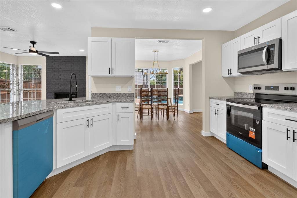 Kitchen featuring white shaker-style cabinetry, stone countertops, wood-finish flooring, and recessed lighting