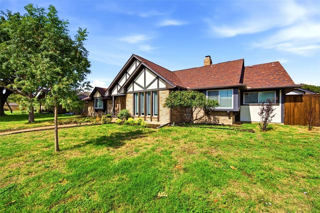 467 Harvest Glen Drive, Richardson, TX 75081 Tudor-style exterior featuring brick and decorative timber framing, a multi-gabled roofline, and an expansive lawn