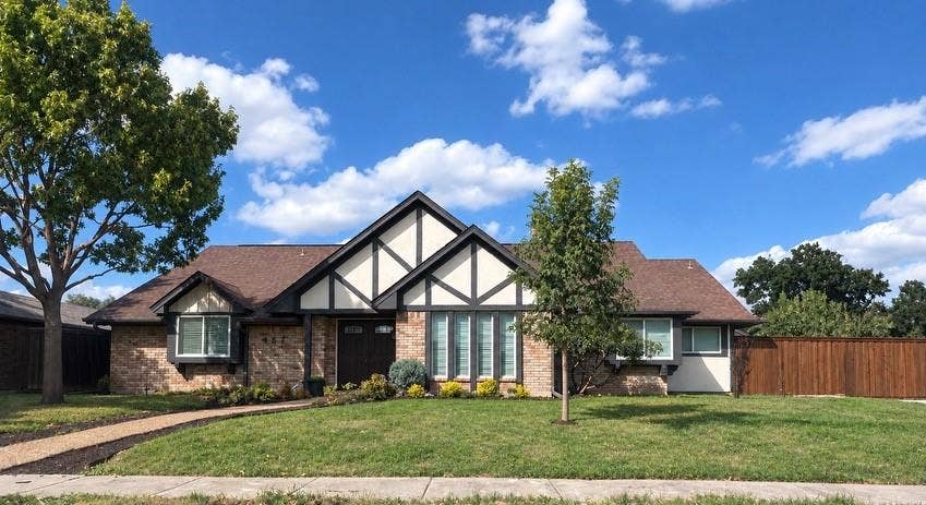 467 Harvest Glen Drive, Richardson, TX 75081 Tudor-style exterior featuring brick and half-timbered detailing, prominent front-facing gables, multi-pane windows, and an expansive front lawn