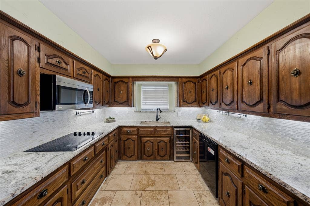 467 Harvest Glen Drive, Richardson, TX 75081 Kitchen featuring raised-panel wood cabinetry, stone countertops, textured tile backsplash, built-in wine refrigerator, and tile flooring
