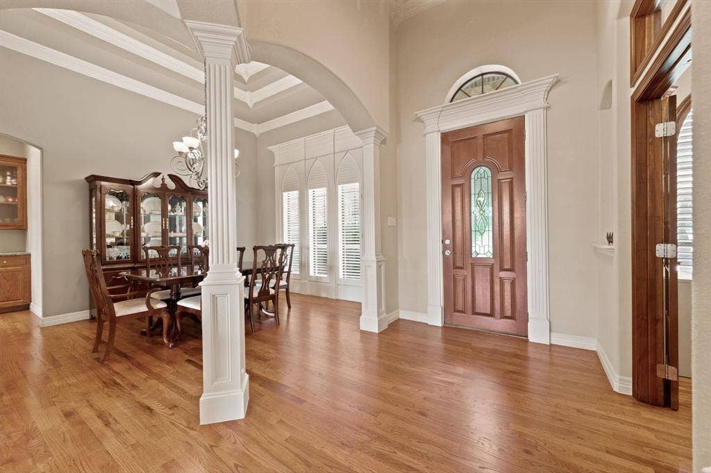 Rich wood-finish flooring throughout the entryway and formal dining space